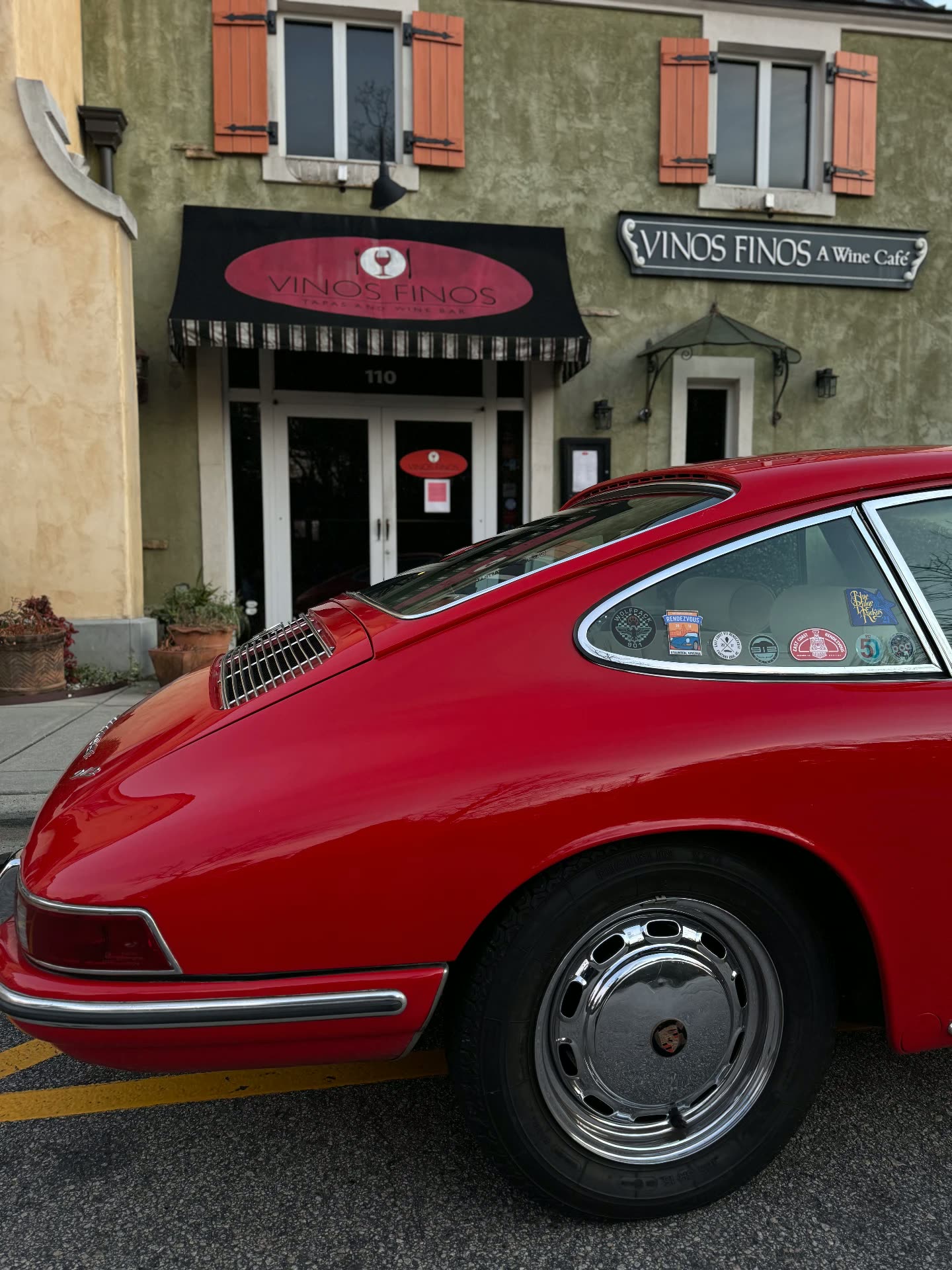 Guards Red early Porsche 911 parked outside a wine cafe