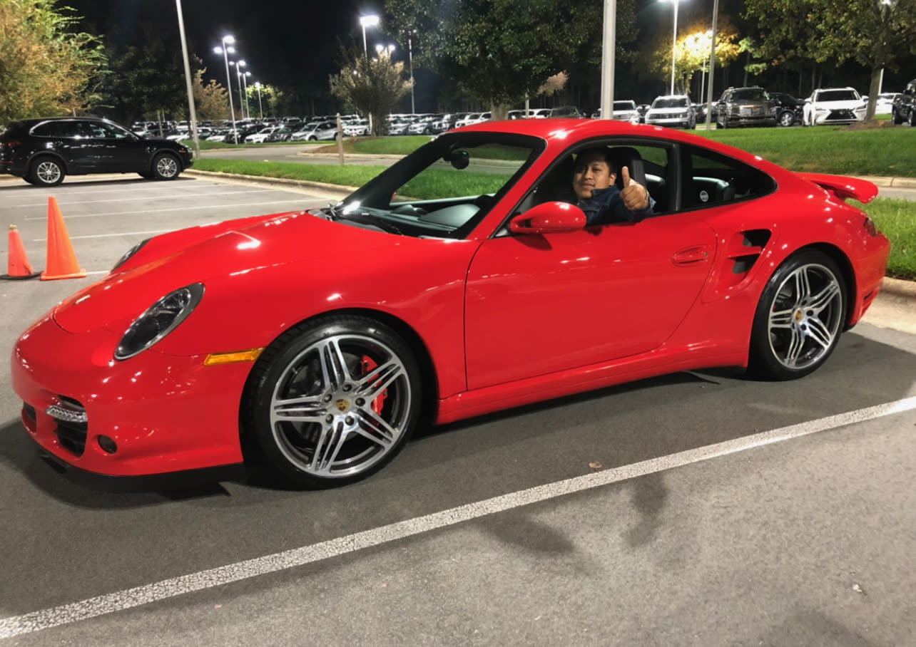 Red Porsche 997 Turbo photographed at night under parking lot lights